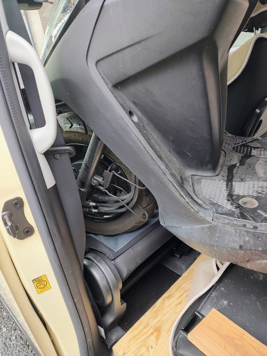 車内に斜めに収まったジョグ。フロントタイヤが助手席と後席の間に入っている